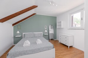 A bedroom with a bed, bedside tables, a dresser, a mirror, and a window. - Torino Regio Parco | Mantova House 2  (Torino)