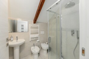 A modern bathroom with a glass-enclosed shower, a sink, and a toilet. - Torino Regio Parco | Mantova House 2  (Torino)