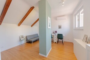 A room with a loft bed, a desk with a chair, a sofa, and a window. - Torino Regio Parco | Mantova House 2  (Torino)
