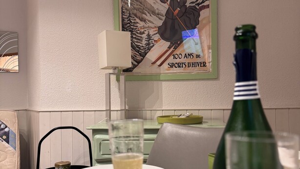 Une table à manger avec une assiette, un verre de champagne et une bouteille de champagne.