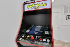 Ein Pac-Man Arcade-Automaten mit Bedienfeld, Spieltitel und Anweisungen.
