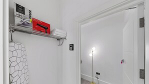 Un baño con perchero, secador de pelo y lámpara de pie.