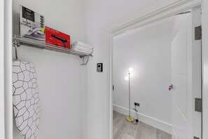 A bathroom with a towel rack, a hair dryer, and a floor lamp. - The Modern Studio London (London)