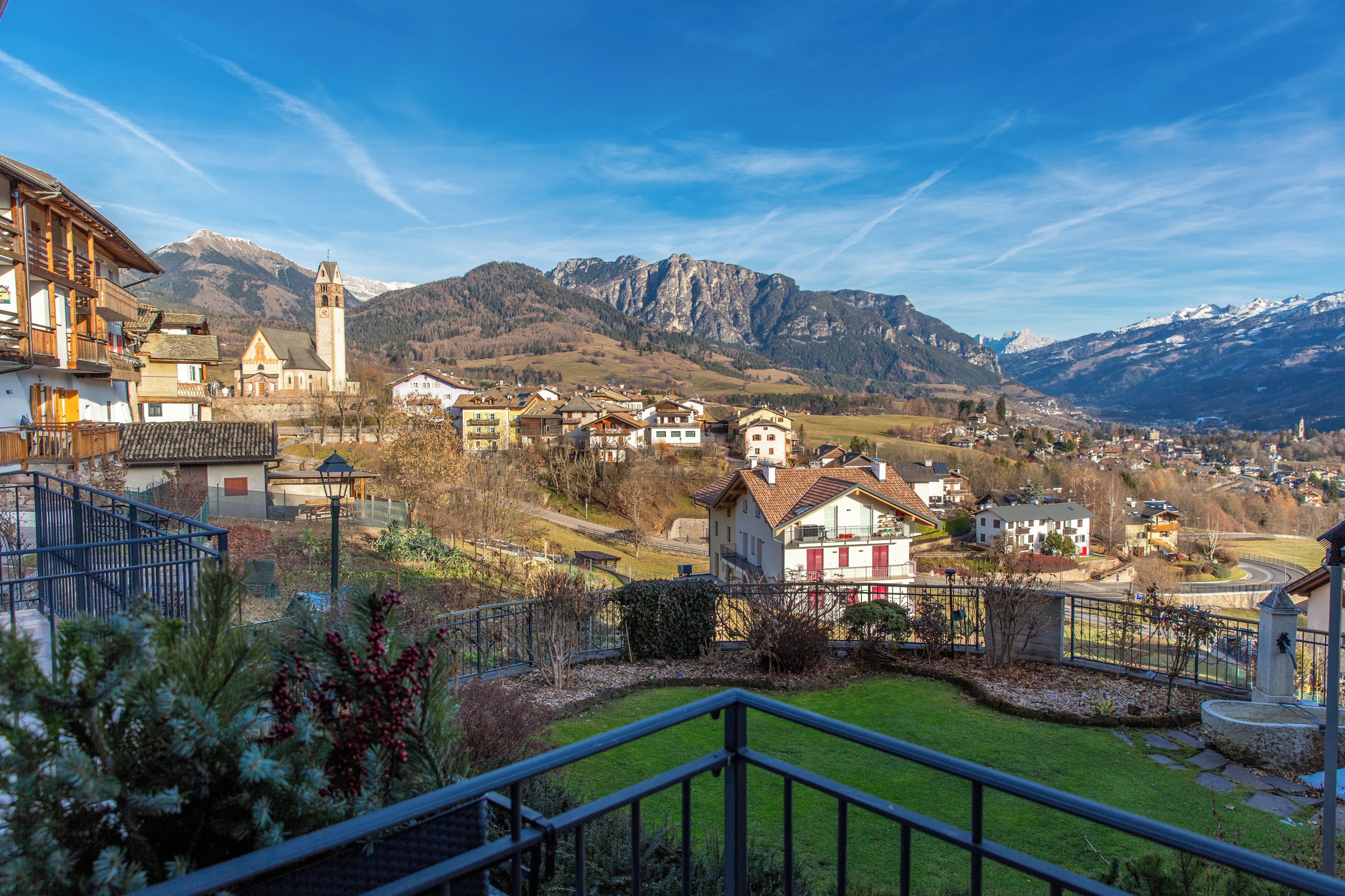 Ein Wohngebiet mit Häusern, einer Kirche und Bergen im Hintergrund.