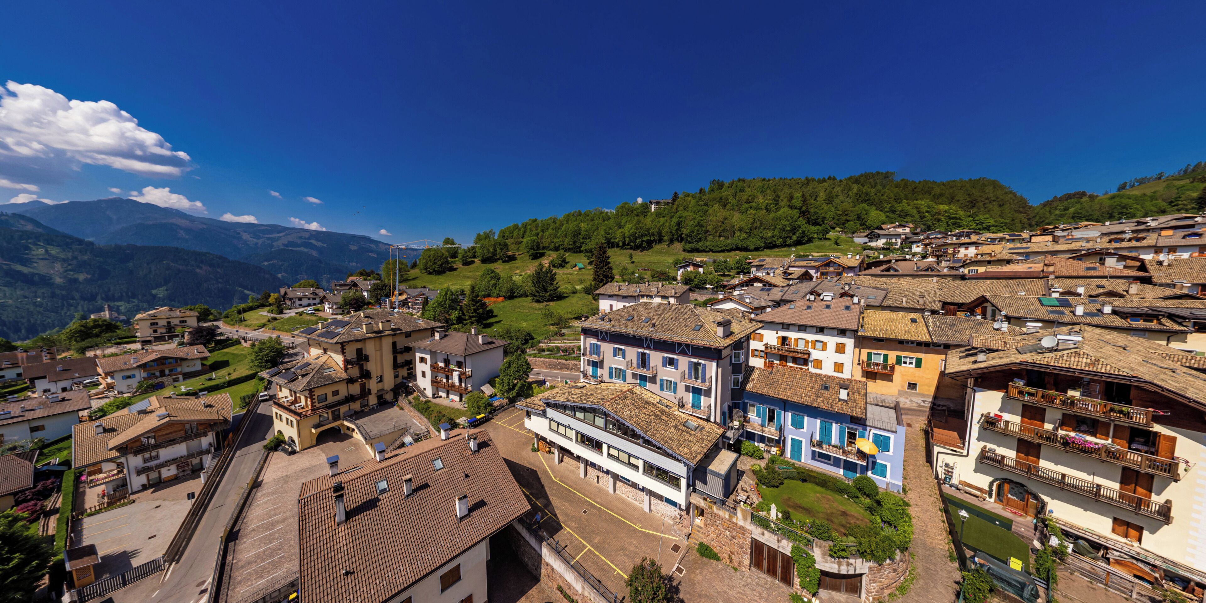 Ein dorfähnliches Bergstädtchen mit traditioneller Architektur, einer zentralen Straße und Blick auf die umliegenden Hügel.