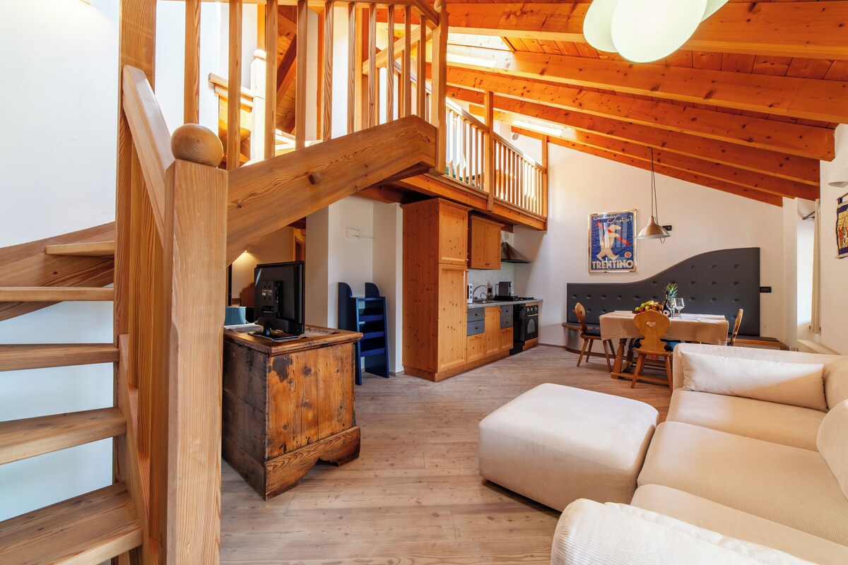 Un intérieur en bois comprenant un escalier, une cuisine et un coin repas.