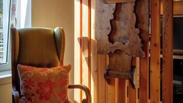Una habitación con estructura de madera, una silla y un panel decorativo en la pared.