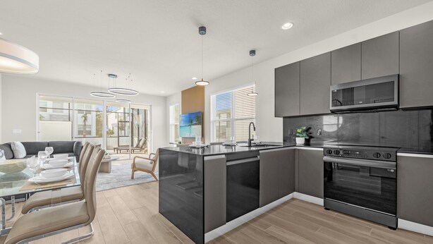 A modern kitchen with a central island, built-in oven, and stainless steel appliances. - Luxury  House 4 Bedroom Family, Private Pool (Clermont)