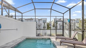 A swimming pool with a glass enclosure, lounge chairs, and a view of modern buildings. - Luxury  House 4 Bedroom Family, Private Pool (Clermont)