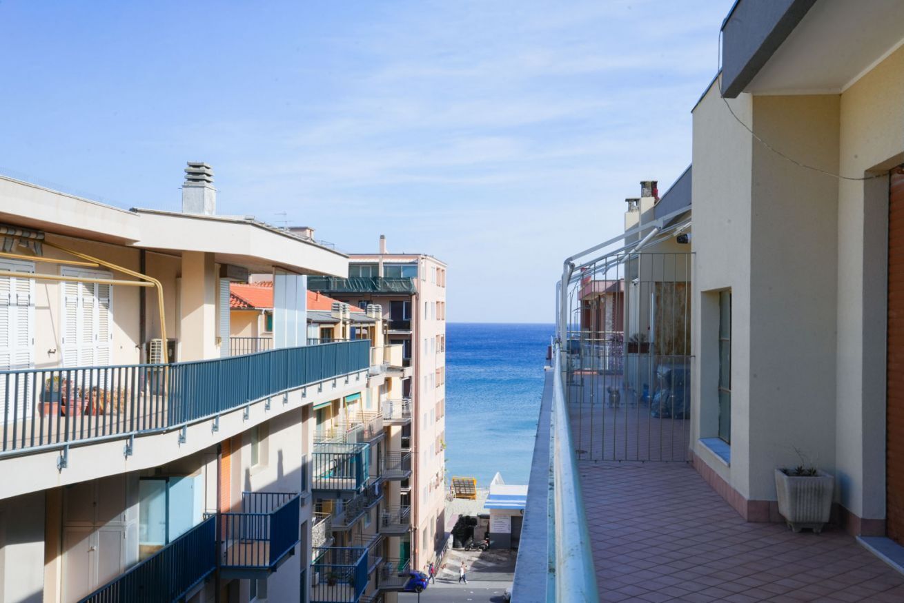 A residential building with balconies overlooking a body of water.