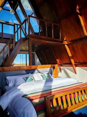 A bedroom with a wooden bunk bed, a staircase, and a skylight.