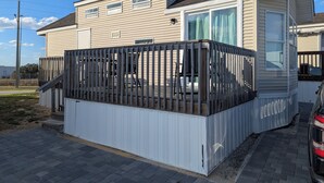 Ein zweistöckiges Haus mit überdachter Terrasse und einem Auto auf der Auffahrt.