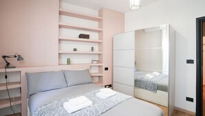 Une chambre à coucher comprenant un lit, des tables de chevet, une armoire et une étagère avec des objets décoratifs.
