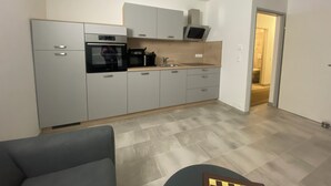 A modern kitchen with grey cabinets, a built-in oven, a microwave, and a sink. - Vacation rental for 4 people, about 2.5 km from the center (Villach)