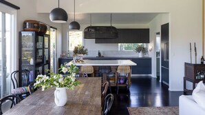 A modern kitchen with a central island, dark cabinetry, and pendant lighting.