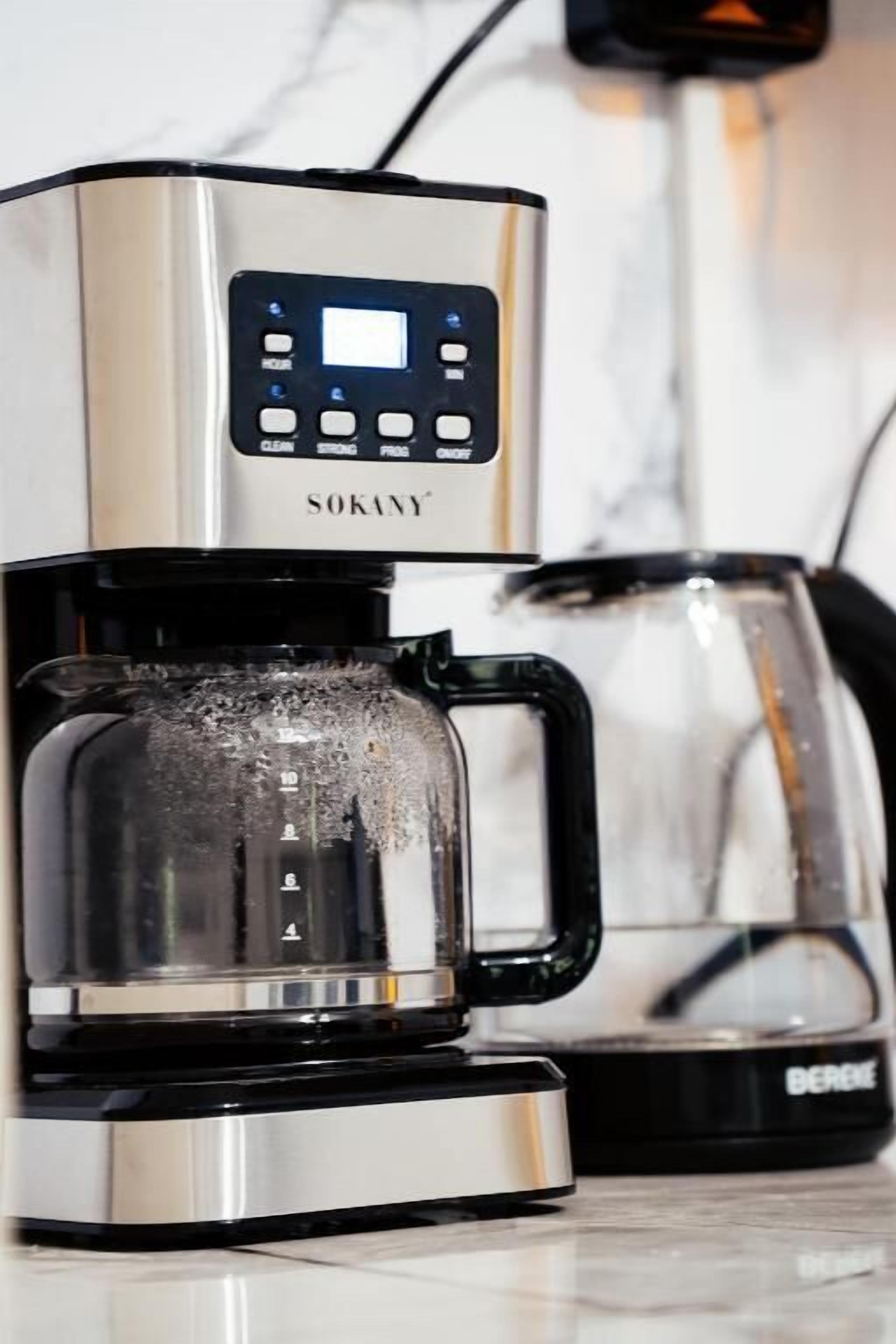 A coffee maker with a digital control panel and a glass carafe.