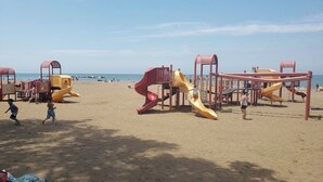 Ein Strandspielplatz mit Rutschen und Klettergerüsten.