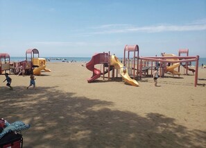 A beach playground with slides and climbing structures. - A Hop ,Skip, and Jump to the Beach (Lorain)