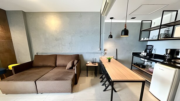 Een moderne woonruimte met een bank, een eettafel en een keukenhoek.