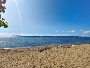 A beach with a clear sky, calm sea, and distant hills. - Les Embruns by Interhome (Sainte Maxime)