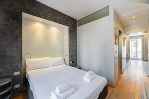 A modern hotel room with a large bed, a bedside table, and a built-in bench. - Torino Centro | Casa Gran Madre (Torino)