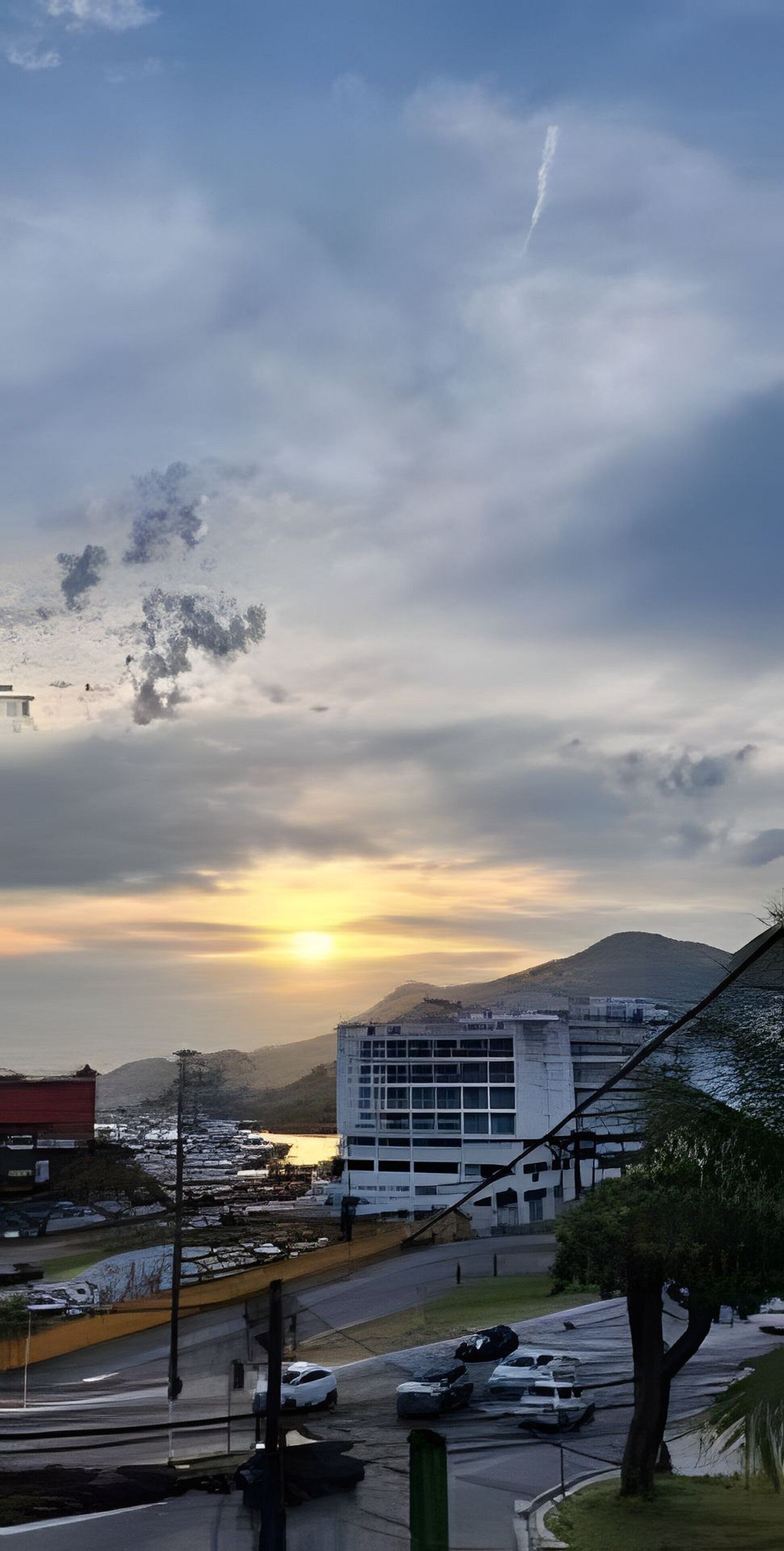 Une vue urbaine comprenant un immeuble, une route et un coucher de soleil.