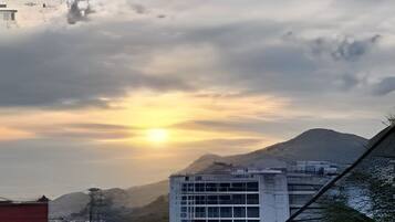 Une vue urbaine comprenant un immeuble, une route et un coucher de soleil.
