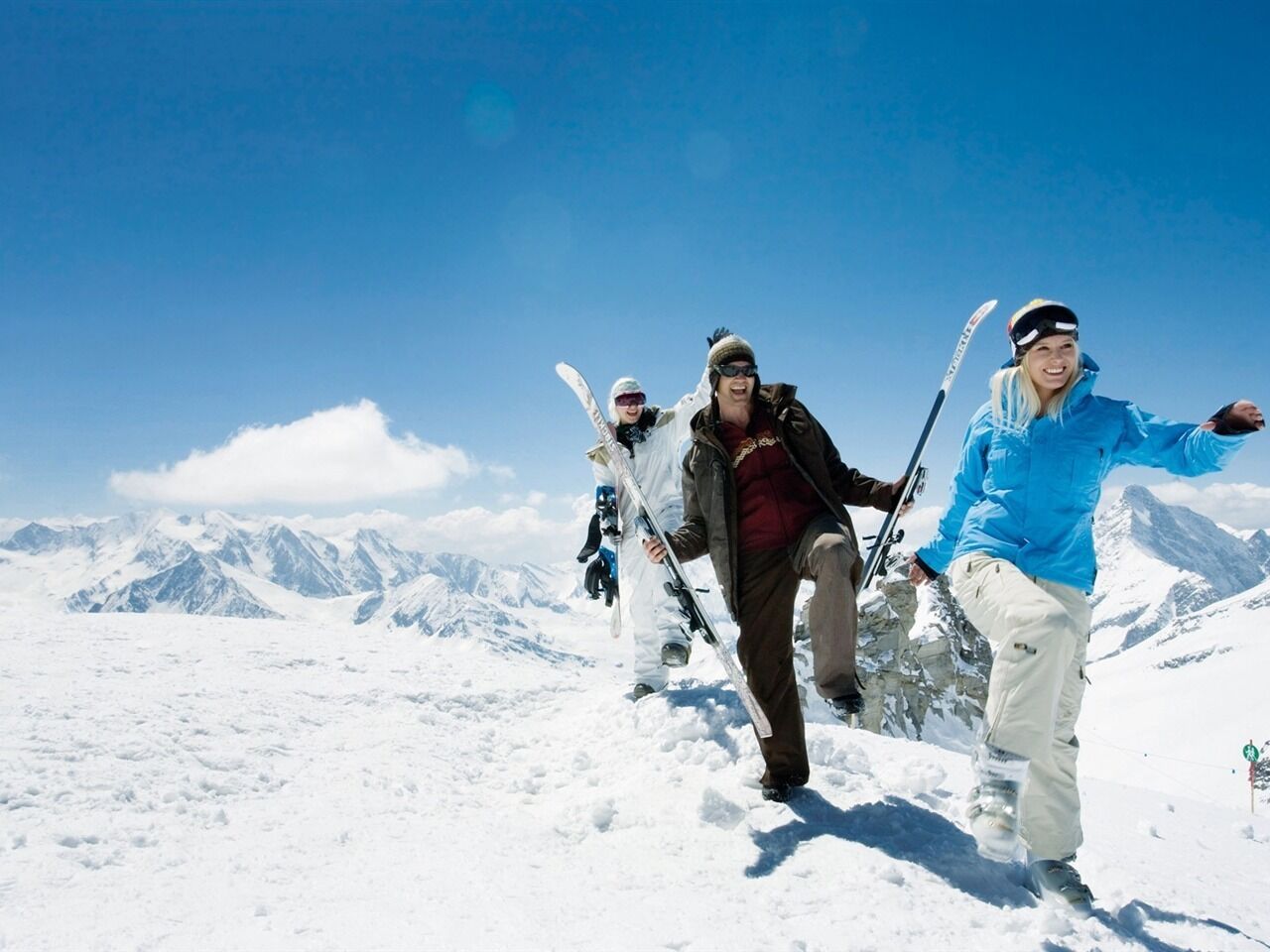 A snowy mountain landscape with skiers.