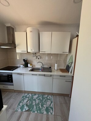 A kitchen with a stove, sink, and cabinets. - The Riscas House—Apartment in Alvor Brisamar (portimao)
