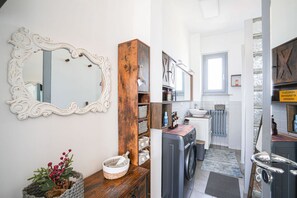 A laundry area with a washing machine, a wooden cabinet, and a mirror. - Piazza Statuto Terrace (Torino)