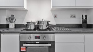 Una cocina moderna con electrodomésticos de acero inoxidable, horno empotrado y campana extractora.