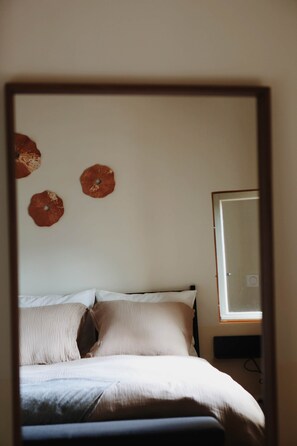 A bedroom with a bed, pillows, a wall-mounted TV, and three wall decorations. - La Valette Boutique - La Grande Valette (Sanilhac-Sagriès)