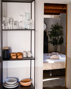 Ein Zimmer mit einer schwarzen Metallregaleinheit, die Glaswaren und Keramik ausstellt.