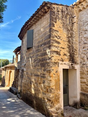 A stone building with a door and a window, surrounded by a gravel path. - La Valette Boutique - La Maison (Sanilhac-Sagriès)
