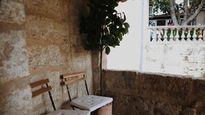 A stone wall with two wooden benches and a potted plant. - La Valette Boutique - La Maison (Sanilhac-Sagriès)