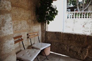 A stone wall with two wooden benches and a potted plant. - La Valette Boutique - La Maison (Sanilhac-Sagriès)