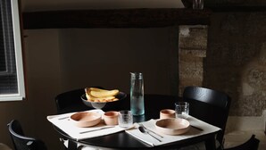 A dining table with chairs, a bowl of bananas, a pitcher, and glasses. - La Valette Boutique - La Maison (Sanilhac-Sagriès)