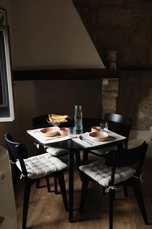 A dining table with chairs, a bowl of bananas, a pitcher, and glasses. - La Valette Boutique - La Maison (Sanilhac-Sagriès)