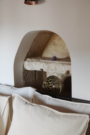 A room with a stone bench, a patterned bowl, and a white bedspread. - La Vallete Boutique - La Petite Valette (Sanilhac-Sagriès)