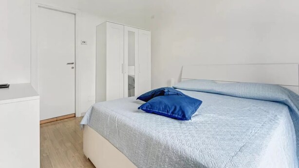 A bedroom with a bed, a wardrobe, and a door. - MOD1 - BEAUTIFUL APARTMENT WITH A TERRACE (Milano)