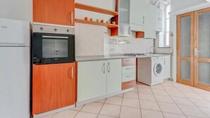 A kitchen with a built-in oven, a washing machine, and a refrigerator. - MOD1 - BEAUTIFUL APARTMENT WITH A TERRACE (Milano)
