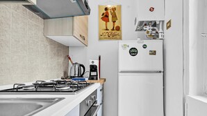 A modern kitchen with a gas stove, a coffee maker, and a refrigerator. - MO10 Pleasant Stay x4 in Milan (Milano)
