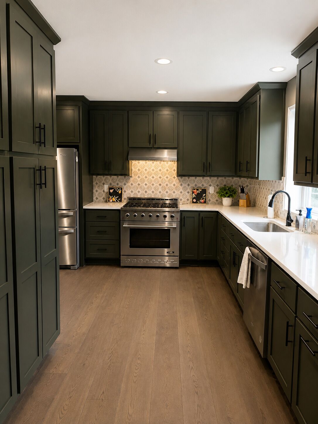 A modern kitchen with dark cabinets, stainless steel appliances, and a tiled backsplash.