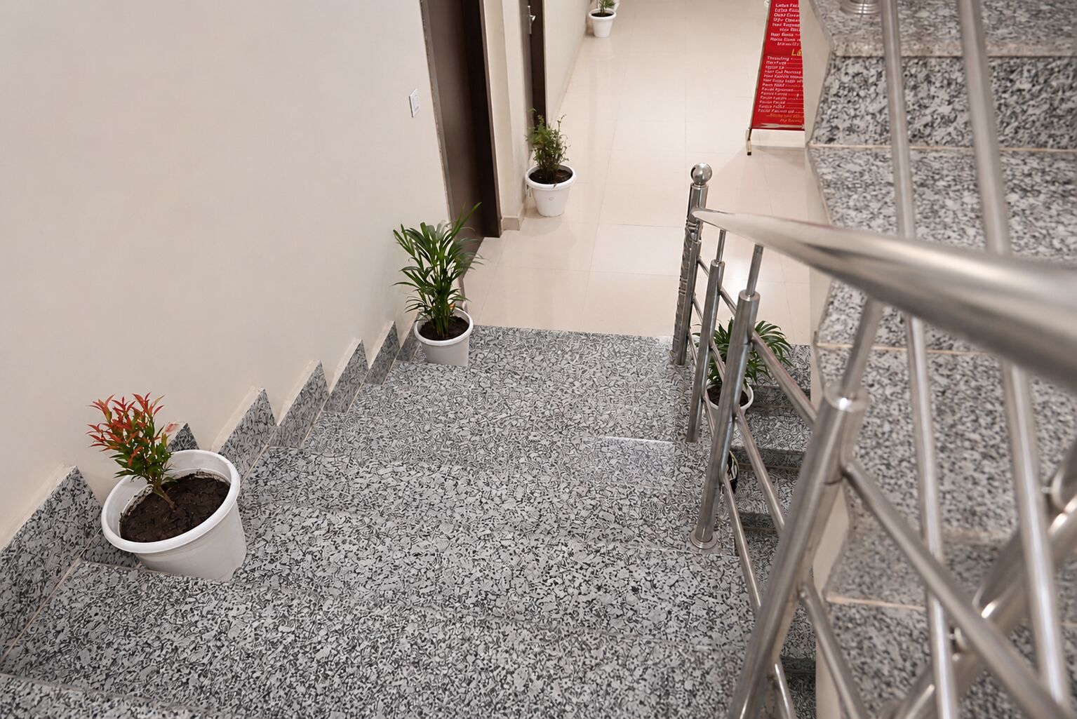 Una escalera con barandillas de metal y plantas en macetas.