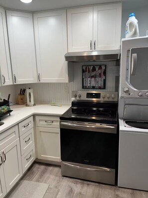 A kitchen with white cabinets, a stainless steel oven, and a microwave.