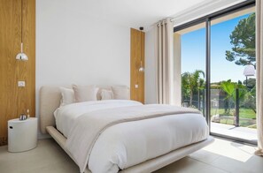 A modern bedroom with a large bed, a bedside table, and a view of the outdoors. - Stunning Villa in Cap d'Antibes for 6 Guests, Ocean View, Air Conditioning (Antibes)