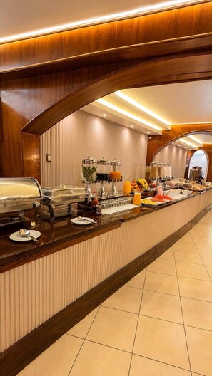 A buffet setup with a variety of food items and beverages, including fruits, cereals, and a coffee station. - INTIWATANA EXCLUSIVE (Cusco)