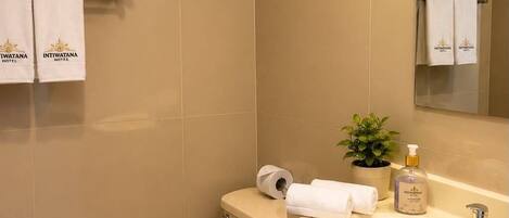 A bathroom with a toilet, sink, and towel rack.