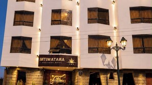 Un hotel de varios pisos con una entrada destacada, señalización iluminada y una fachada bien iluminada.