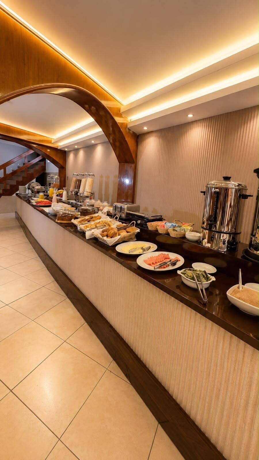 A buffet setup with various food items and beverages, a coffee machine, and a water dispenser.